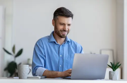 Smiling man at his desk.