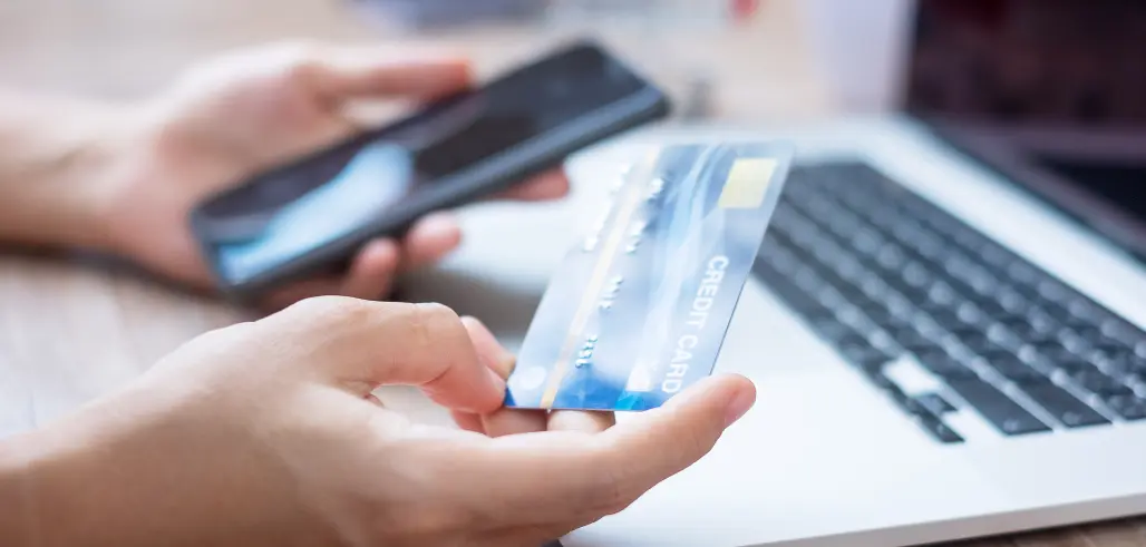 woman hand holding credit card with using smartphone and laptop for online shopping while making orders at home. business, lifestyle, technology, ecommerce, digital banking and online payment concept