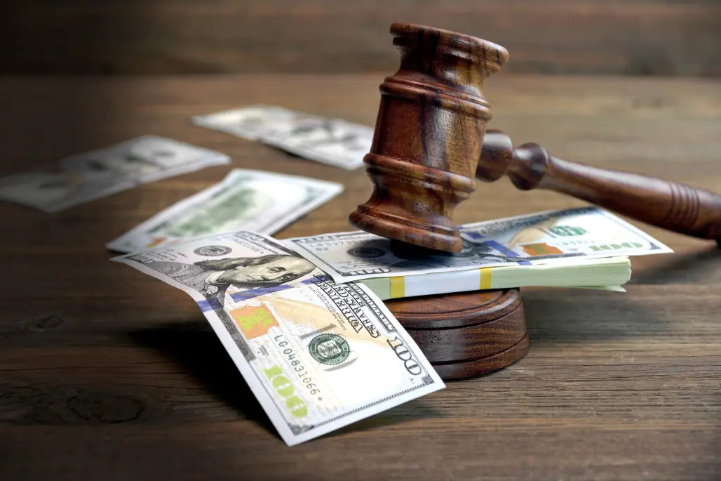 Bundle Of Money, Judges Gavel And Soundboard On Wooden Table